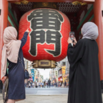 ふたりのムスリム女性が雷門をスマホで撮影