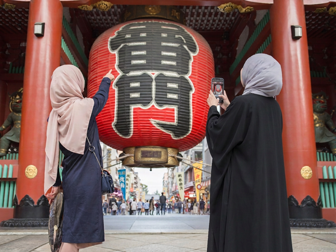 ふたりのムスリム女性が雷門をスマホで撮影